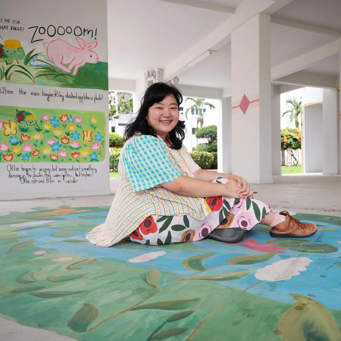 Artist Dorcas Tang, 24, pictured with her murals on Nov 25.
