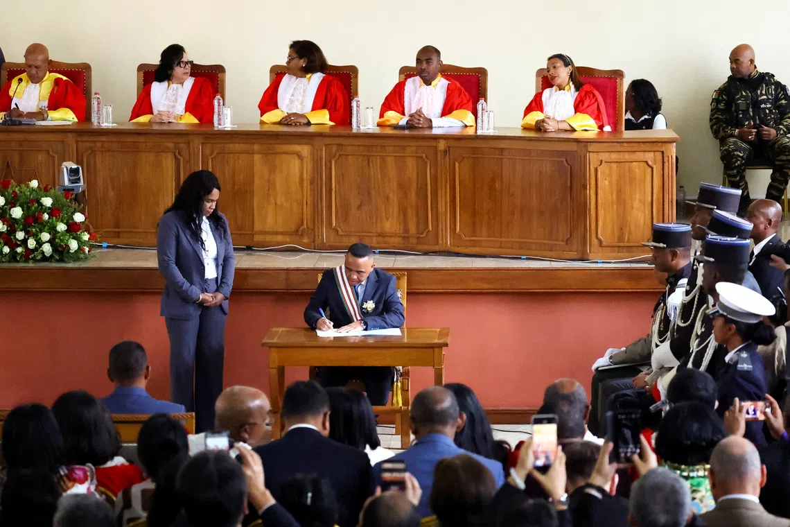 Madagascar's new military ruler, Colonel Michael Randrianirina, signs documents after being sworn in as president on Friday, taking over from Andry Rajoelina following a coup that ousted him, at the constitutional court in Antananarivo, Madagascar, October 17, 2025. REUTERS/Siphiwe Sibeko