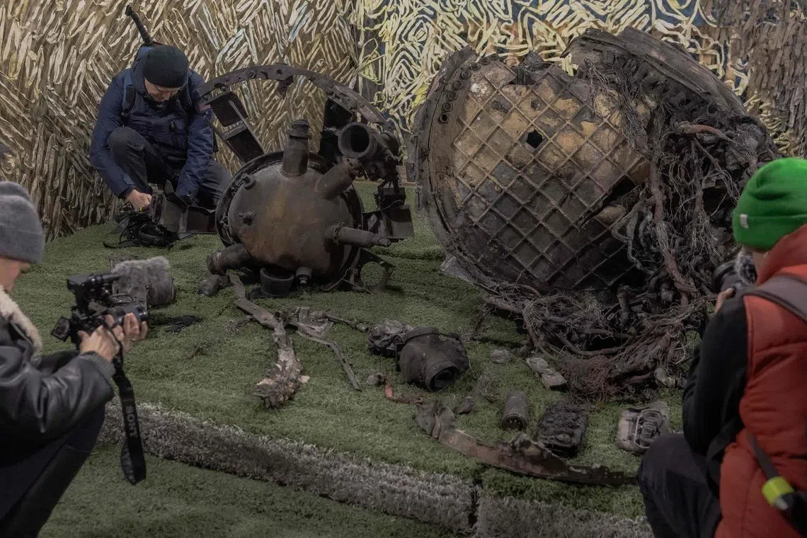 Members of the media taking photos and video of the debris collected by Ukrainian officials after a Nov 21 Russian missile attack on the Ukrainian city of Dnipro.
