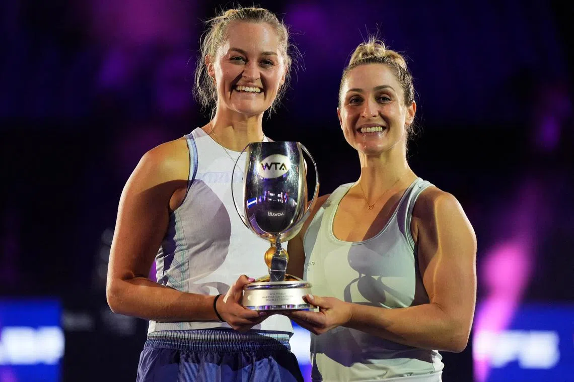 Canada's Gabriela Dabrowski and New Zealand's Erin Routliffe celebrate with the trophy after winning their women's doubles final match at the WTA Finals.
