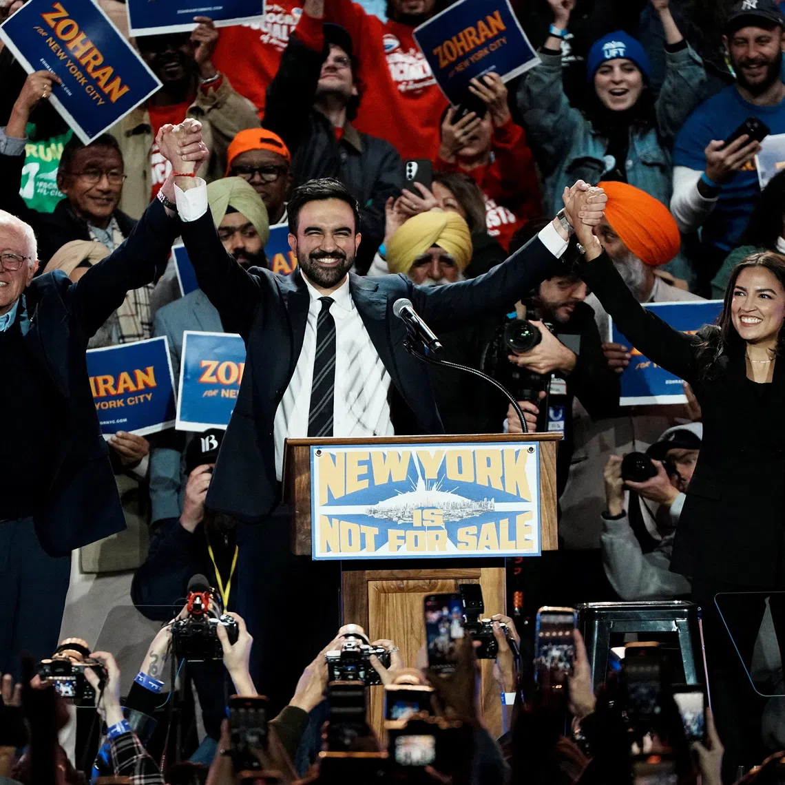 New York City mayoral candidate Zohran Mamdani, U.S. Senator Bernie Sanders (I-VT) and U.S. Representative Alexandria Ocasio-Cortez (D-NY) react on stage during a \"New York is Not For Sale\" rally at Forest Hills Stadium, in the Queens borough of New York City, U.S., October 26, 2025. REUTERS/Eduardo Munoz