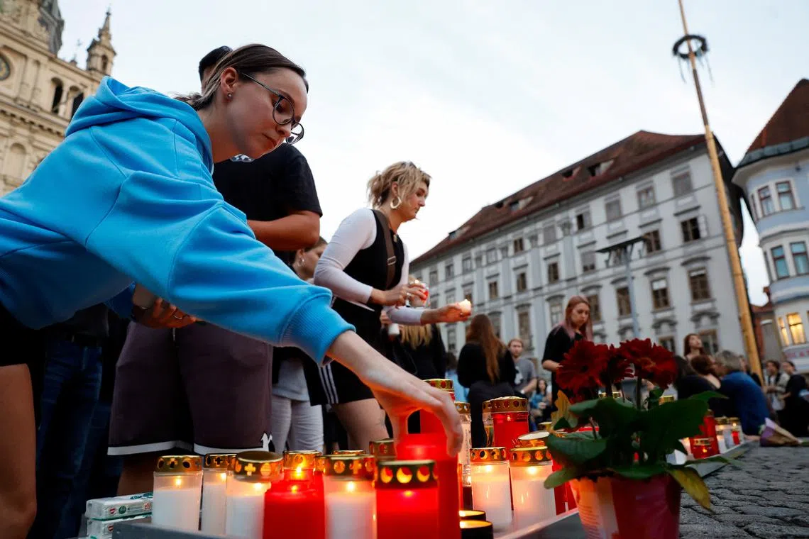 People light candles in the main square following a deadly school shooting in Graz, Austria, June 10, 2025.  REUTERS/Borut Zivulovic