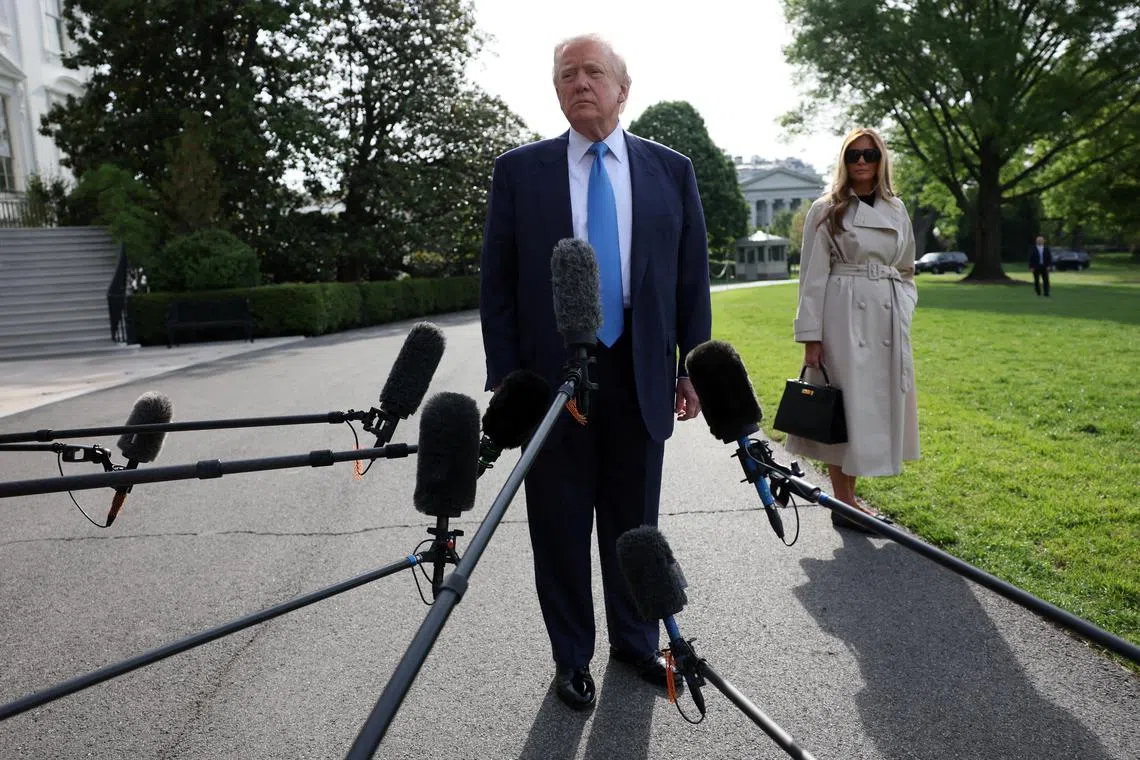 U.S. President Donald Trump speaks to members of the media next to first lady Melania Trump as they depart for Rome, Italy, to attend Pope Francis' funeral, at the White House in Washington, D.C., U.S., April 25, 2025. REUTERS/Leah Millis