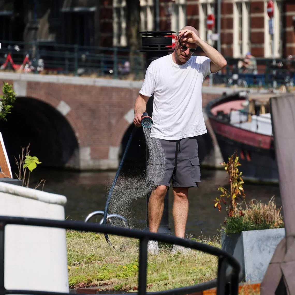 A houseboat resident watering his plants during a heatwave in Amsterdam, the Netherlands, on June 26.