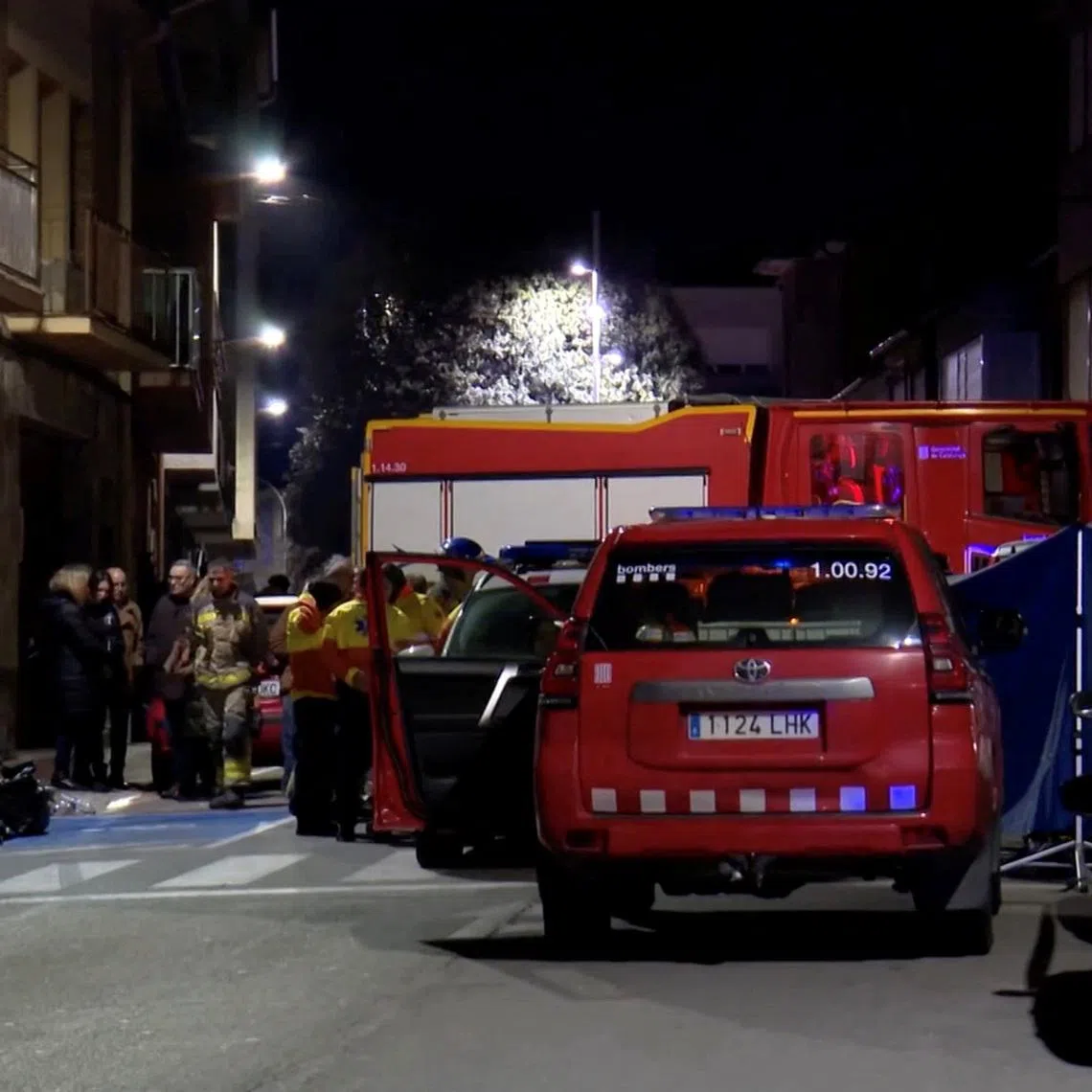 Emergency personnel stand outside an apartment building that caught fire and killed five young people, in Manlleu, in the Catalonia region, Spain, in this screen grab taken from a video obtained on February 17, 2026. FORTA/Handout via REUTERS