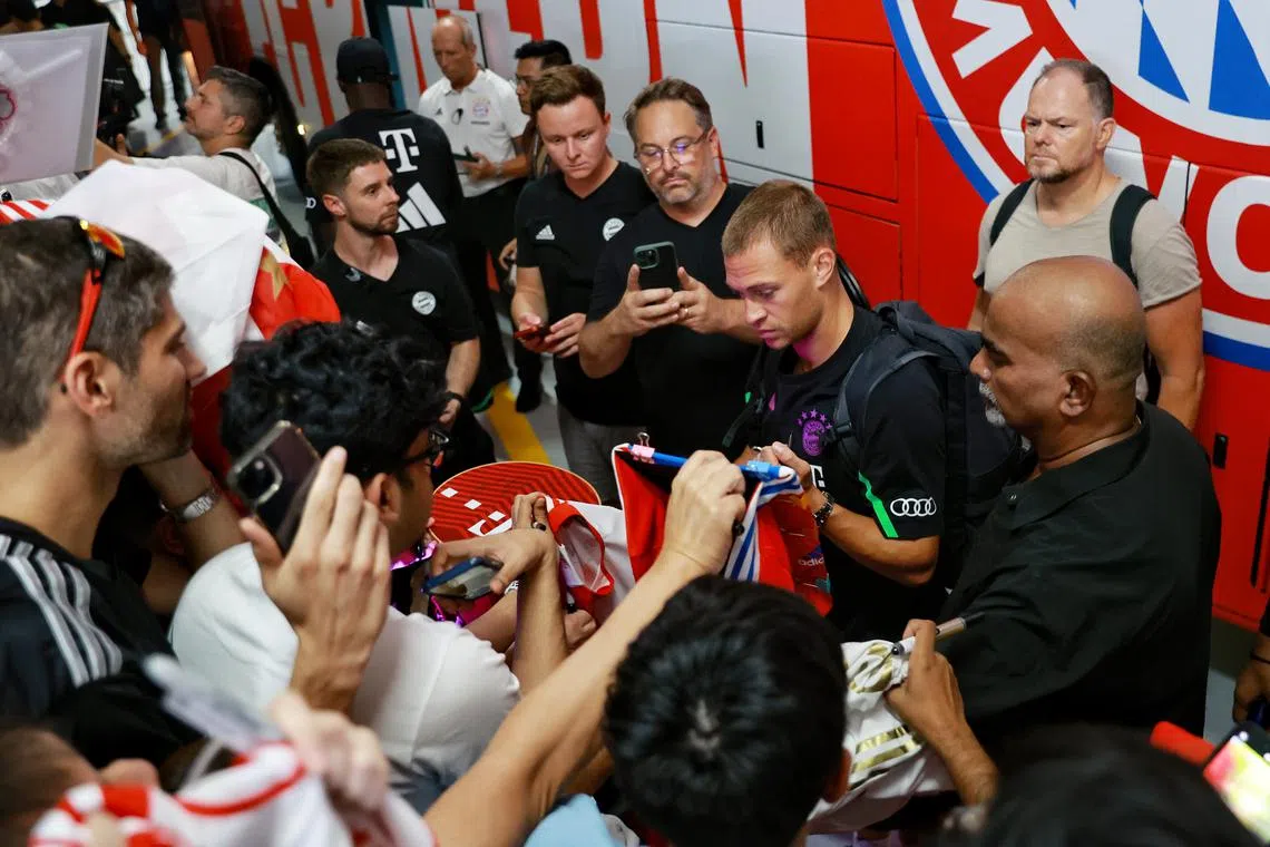 Bayern Munich’s Joshua Kimmich signing autographs for fans at the basement carpark of Andaz Singapore on Sunday.