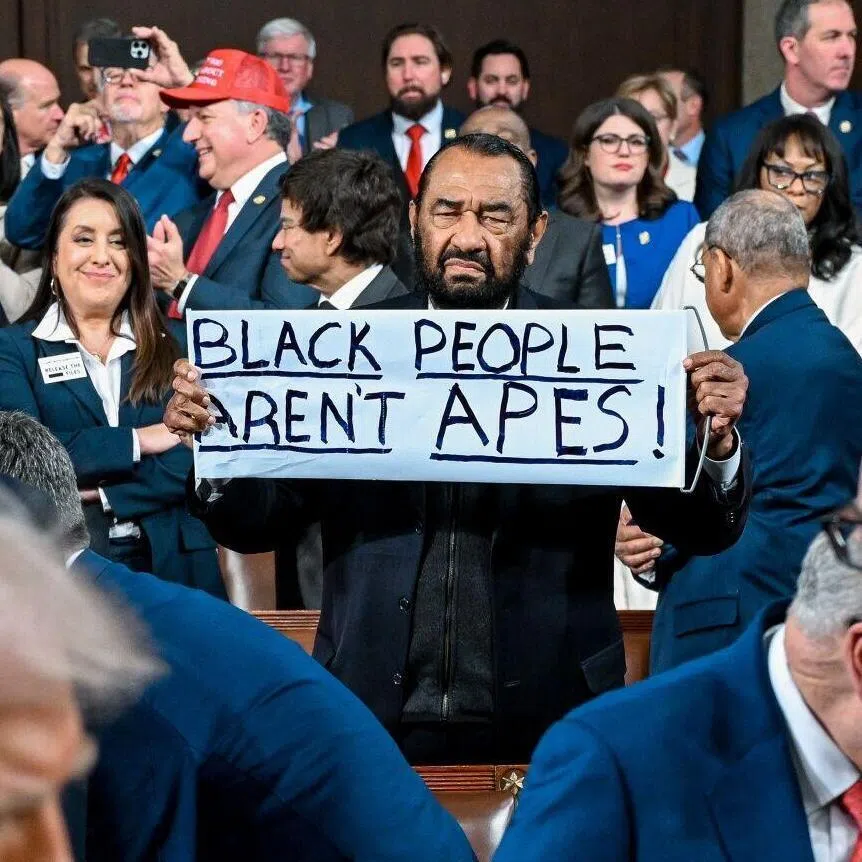 US Democratic Representative Al Green, of Texas, holds a "Black People Aren't Apes" sign as President Donald Trump arrives for a State of the Union address in the House Chamber of the US Capitol in Washington, DC, on Feb 24 