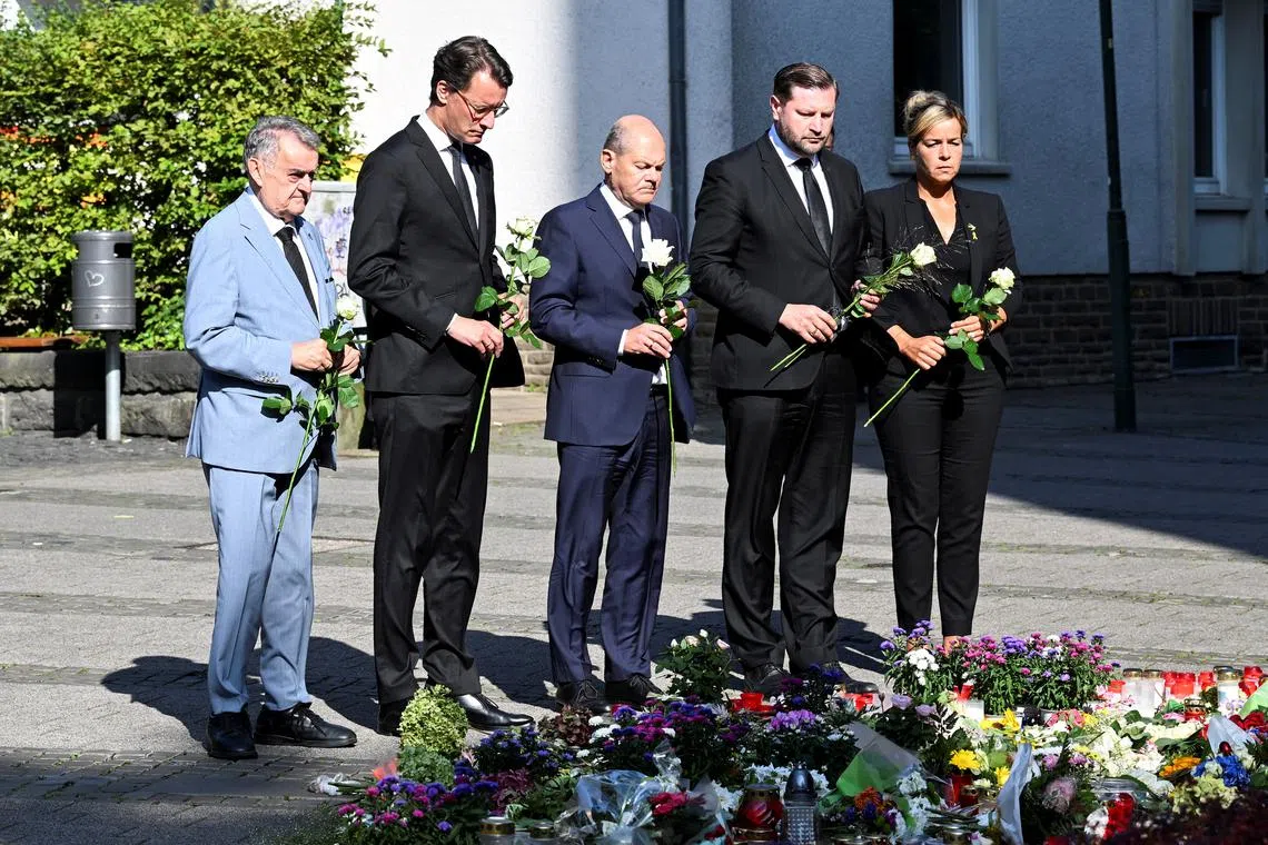 North Rhine-Westphalia state premier Hendrik Wuest, Solingen mayor Tim Kurzbach and German Chancellor Olaf Scholz pay their respects at the site where three people were killed and several injured in a stabbing attack at a festival, in Solingen, Germany, August 26, 2024. REUTERS/Jana Rodenbusch