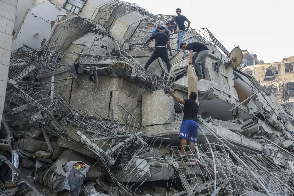 Residents inspect a damaged building after Israeli warplanes bombed Gaza City.