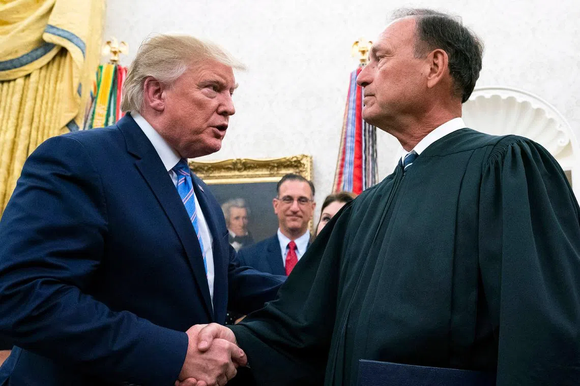 Donald Trump (left) shakes hands with Justice Samuel Alito in the Oval Office of the White House in Washington, on July 23, 2019.