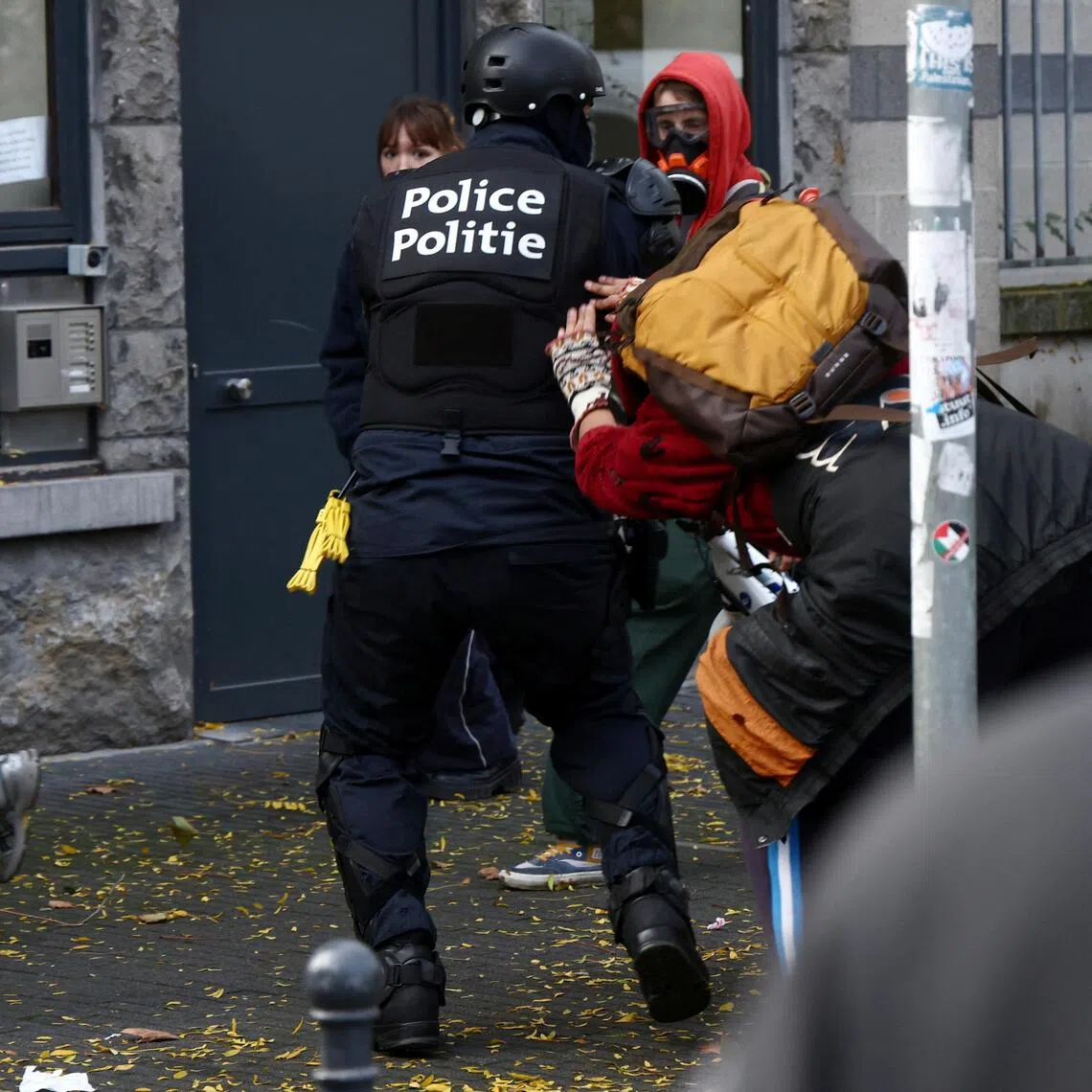A police officer scuffling with demonstrators in Brussels, Belgium, on Oct 24.