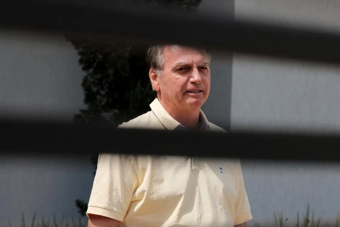 FILE PHOTO: Brazil's former President Jair Bolsonaro stands at his home while under house arrest, amid the final phase of Brazil's former President Jair Bolsonaro's trial, accused of plotting a coup after his electoral defeat, in Brasilia, Brazil, September 3, 2025. REUTERS/Diego Herculano/File Photo