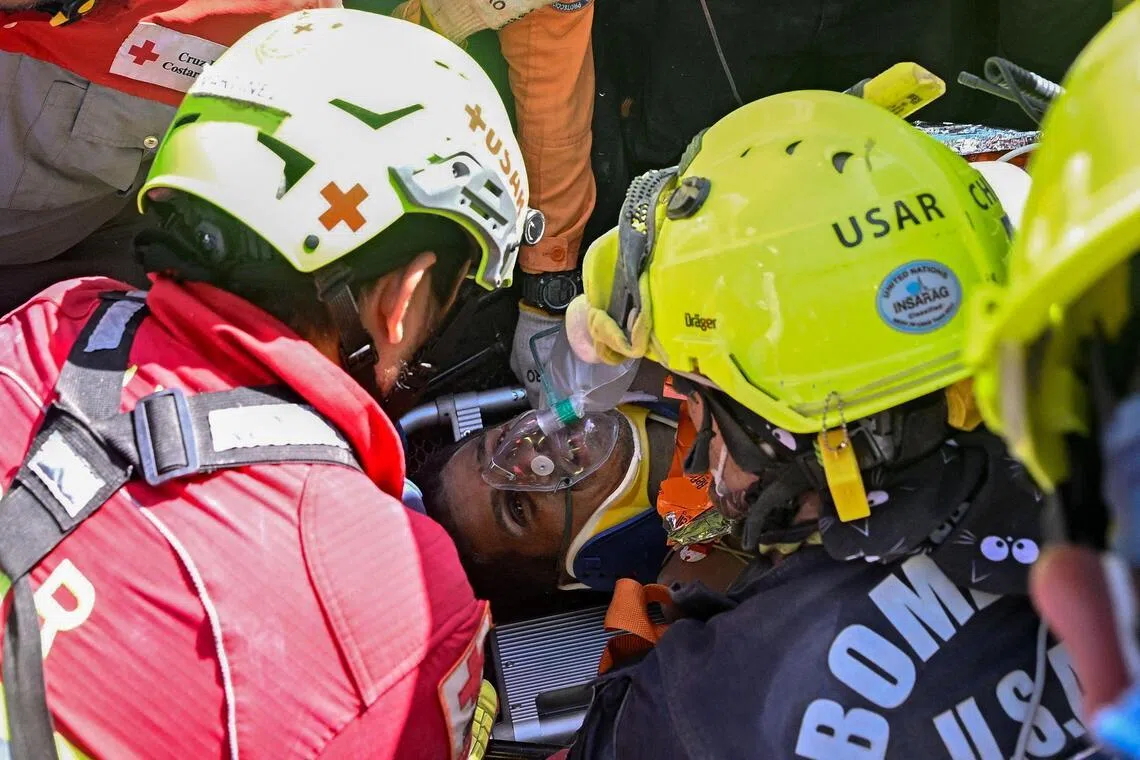 An international rescue team assists a survivor of Venezuela’s twin earthquakes in Catia La Mar, La Guaira State, Venezuela on July 2, eight days after the quake.