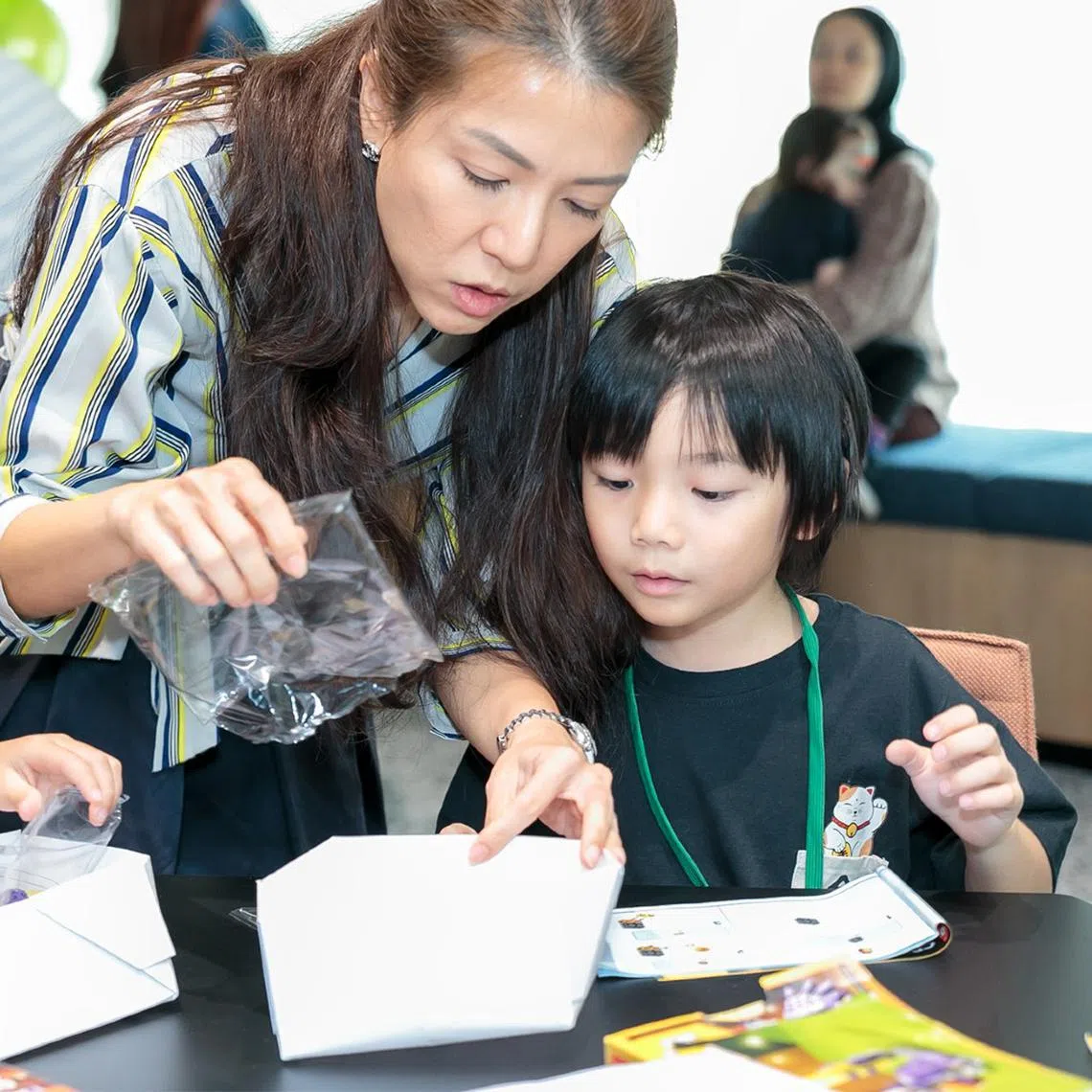 Ms Cynthia Liang (left) and her son participate in an activity together at her workplace.