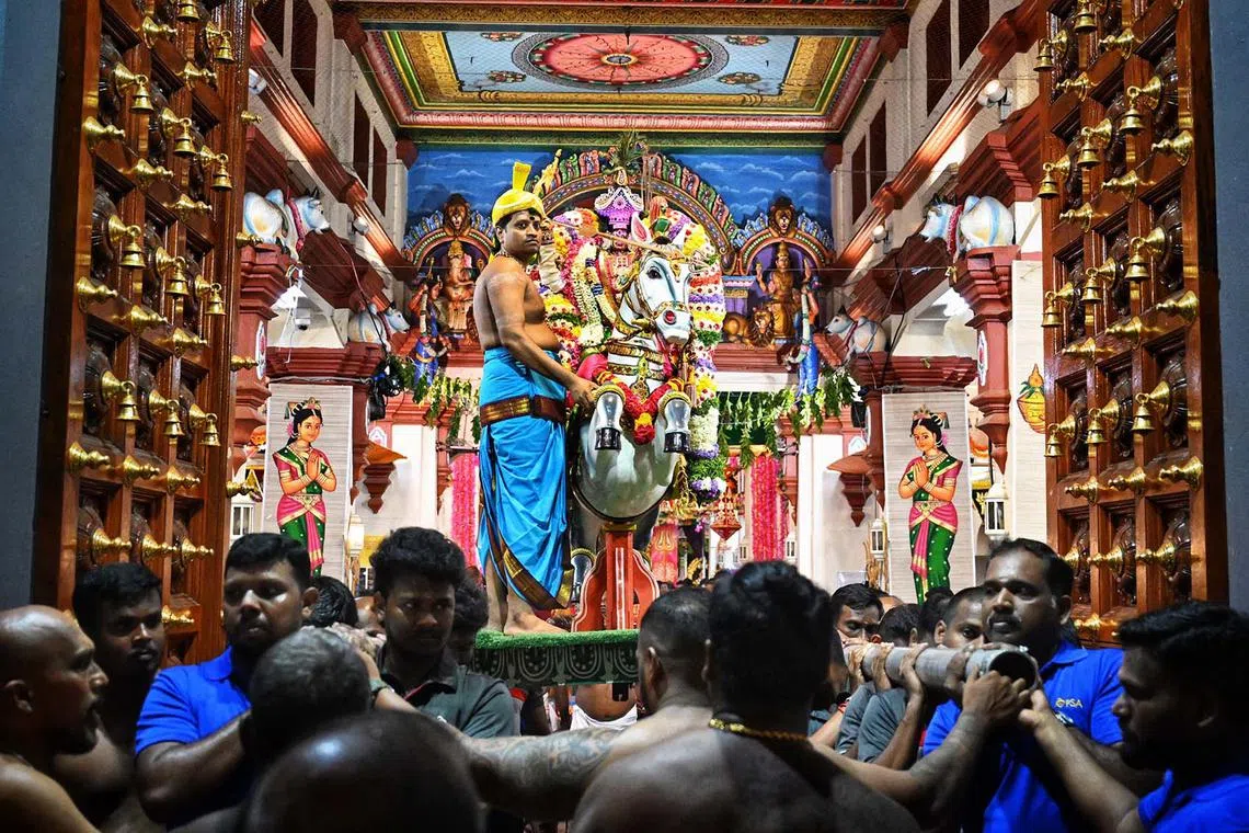 The head priest of Sri Mariamman Temple, Venugopal Thirunavukarasu, 42, and the horse vehicle of Goddess Sri Mariamman, are carried by 20 volunteers as they go on a procession to bless devotees attending the Vijayadashami celebrations at Sri Mariamman Temple on Oct 12, 2024. 