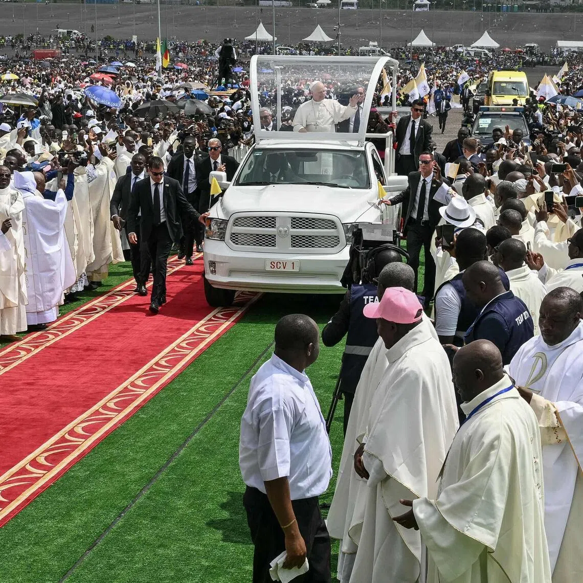 Pope Leo XIV waving to the crowd from the Popemobile as he arrives to lead a Mass in Douala on April 17, the fifth day of his 11-day visit to Africa.