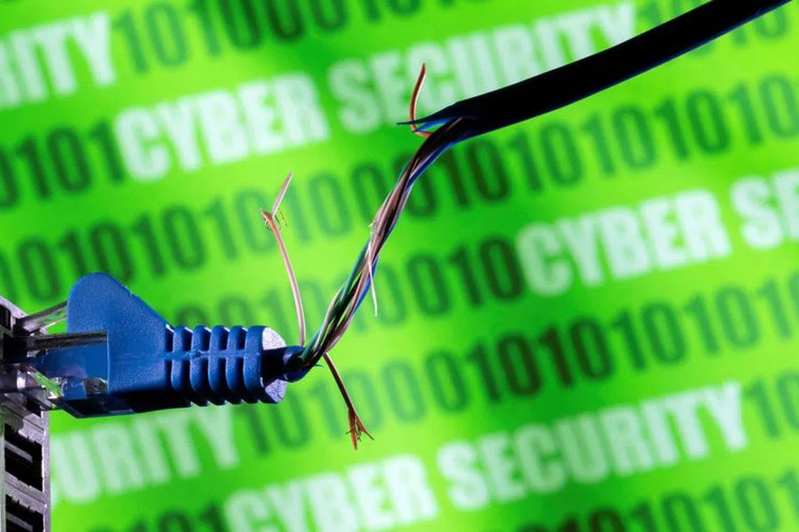 FILE PHOTO: Broken Ethernet cable is seen in front of binary code and words \"cyber security\" in this illustration taken March 8, 2022. REUTERS/Dado Ruvic/Illustration//File Photo