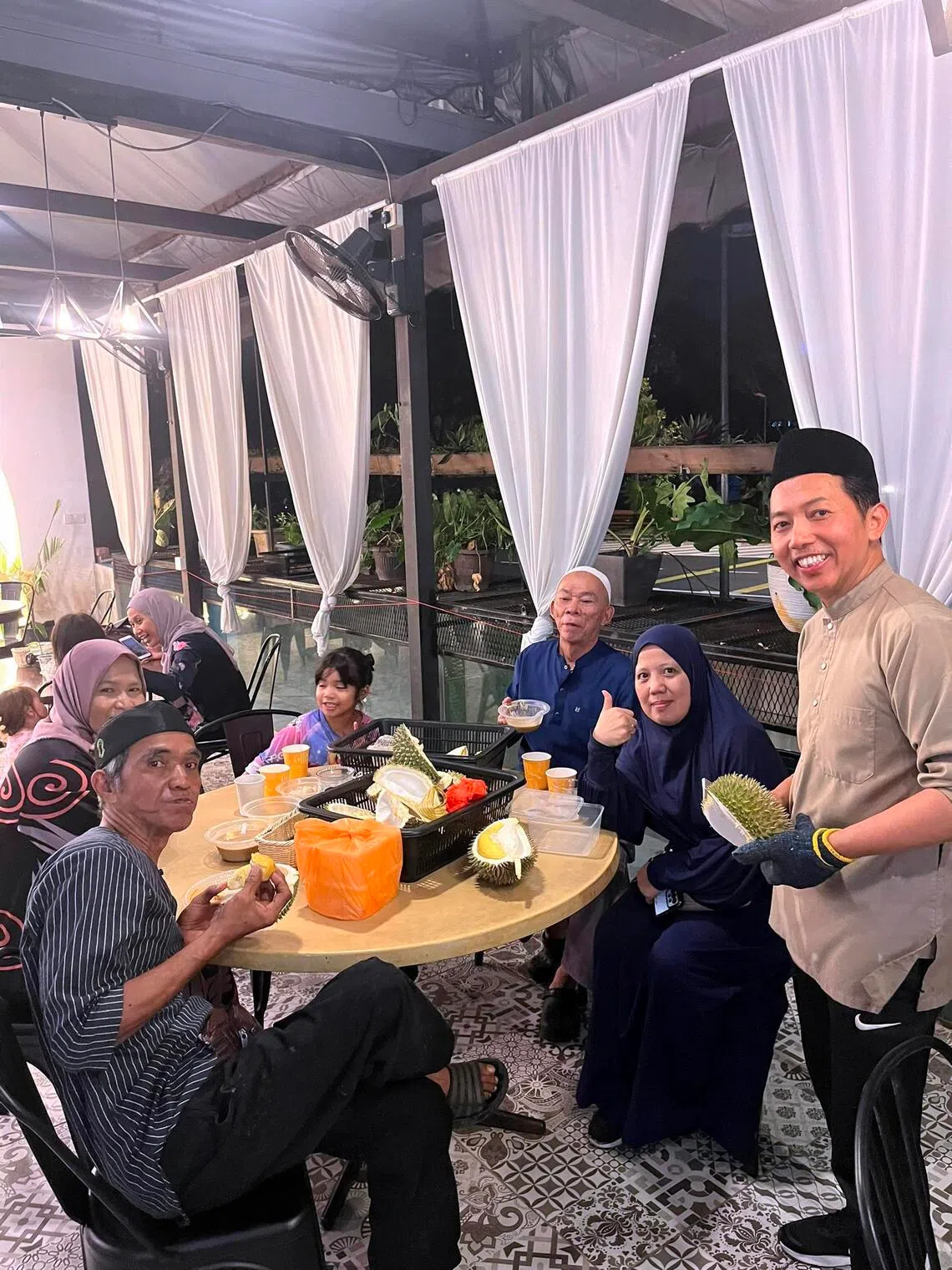 Guests at a durian party organised by EzyDurian in Bangi, Selangor, pictured with founder Khairul Anuar Mohamadiah (right).