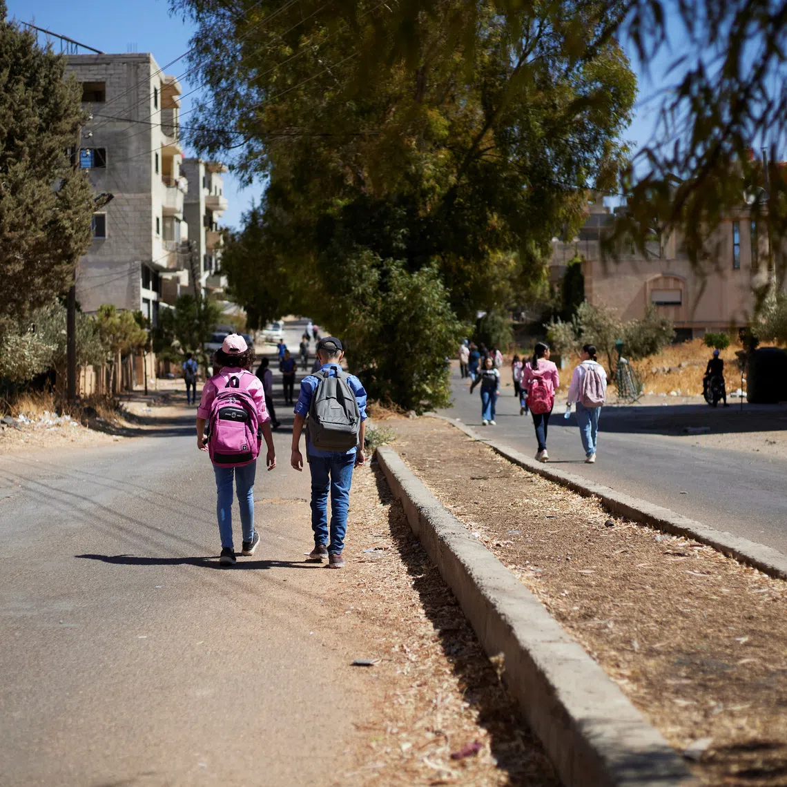 A group of students walk along a street in the city of Shahba, Sweida province, Syria, September, 26, 2026. REUTERS/Kinan hlal