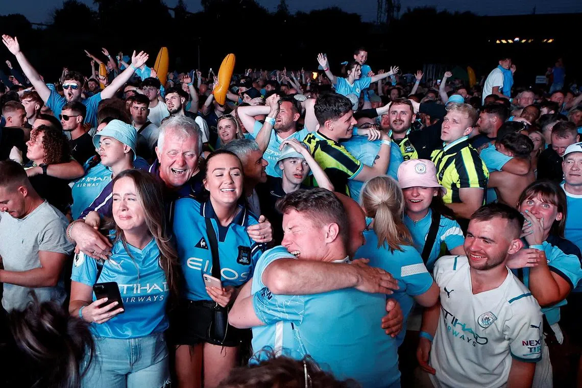 Manchester City fans at Manchester's 4TheFans Fan Park  celebrating after their team won the Champions League final on Saturday night.    
