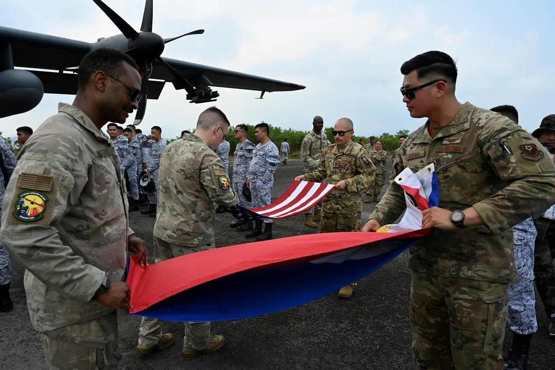 In this file photo taken on April 23, 2023, US soldiers fold a US and Philippine flag at Subic Bay Freeport Zone as part of the US-Philippines joint military exercise ‘Balikatan’. 