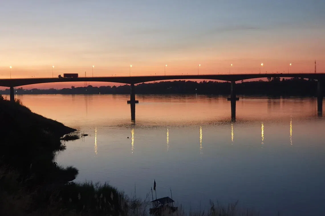 The bridge across the Mekong River during dusk. Laos is on the far side and Thailand is on the near side.