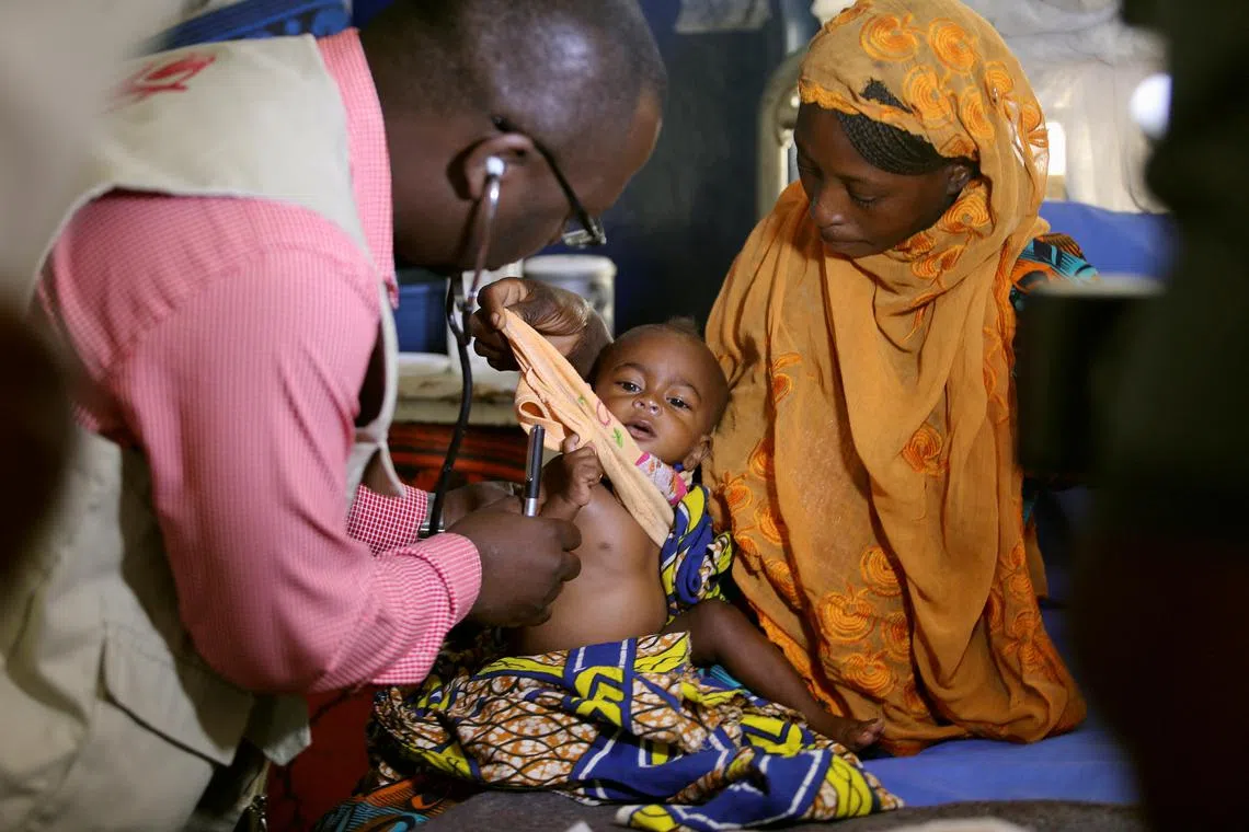 FILE PHOTO: A doctor examines a malnourished baby at the Save the Children stabilisation ward in Maiduguri, Nigeria November 30, 2016. Picture taken November 30, 2016.
