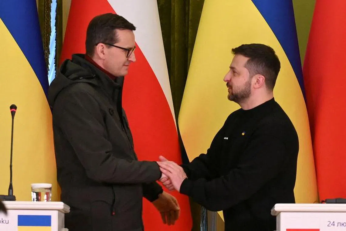 FILE PHOTO: Ukraine's President Volodymyr Zelenskiy and Polish Prime Minister Mateusz Morawiecki shake hands during a joint news briefing on a day of the first anniversary of Russia's attack on Ukraine, in Kyiv, Ukraine February 24, 2023.  REUTERS/Viacheslav Ratynskyi/File Photo