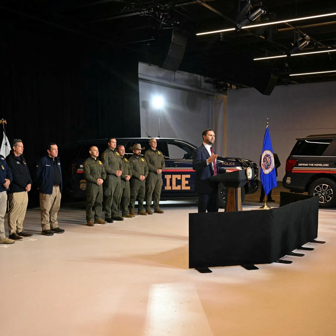 ICE vehicles sit in the background as federal immigration agents listen to U.S. Vice President JD Vance speak at Royalston Square in Minneapolis, Minnesota, U.S. January 22, 2026. Jim Watson/Pool via REUTERS