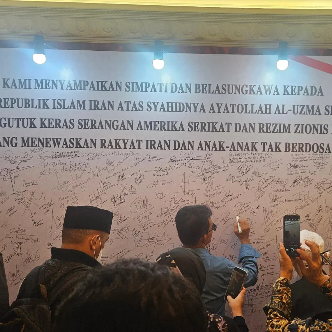 Visitors took turns to sign a condolence board at the official residence of Iranian Ambassador Mohammad Boroujerdi.
