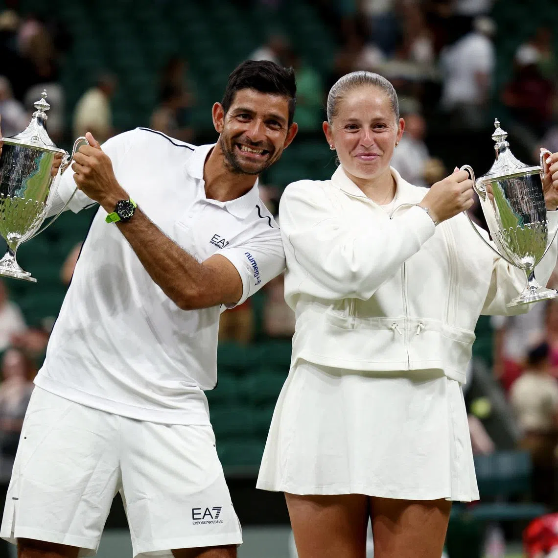 Tennis - Wimbledon - All England Lawn Tennis and Croquet Club, London, Britain - July 9, 2026  El Salvador's Marcelo Arevalo and Latvia's Jelena Ostapenko pose with the trophies after winning their mixed doubles final match against Australia's Marc Polmans and Australia's Storm Hunter REUTERS/Marko Djurica