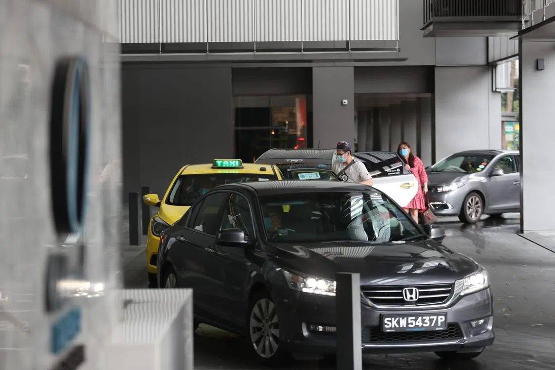 Office workers alighting from taxis and private-hire car at OUE Downtown building on 20 November 2020. 