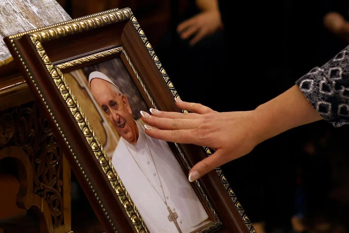 A Christian worshipper touching a portrait of Pope Francis for a blessing, during a memorial mass for the late pontiff in Israel, on April 24.