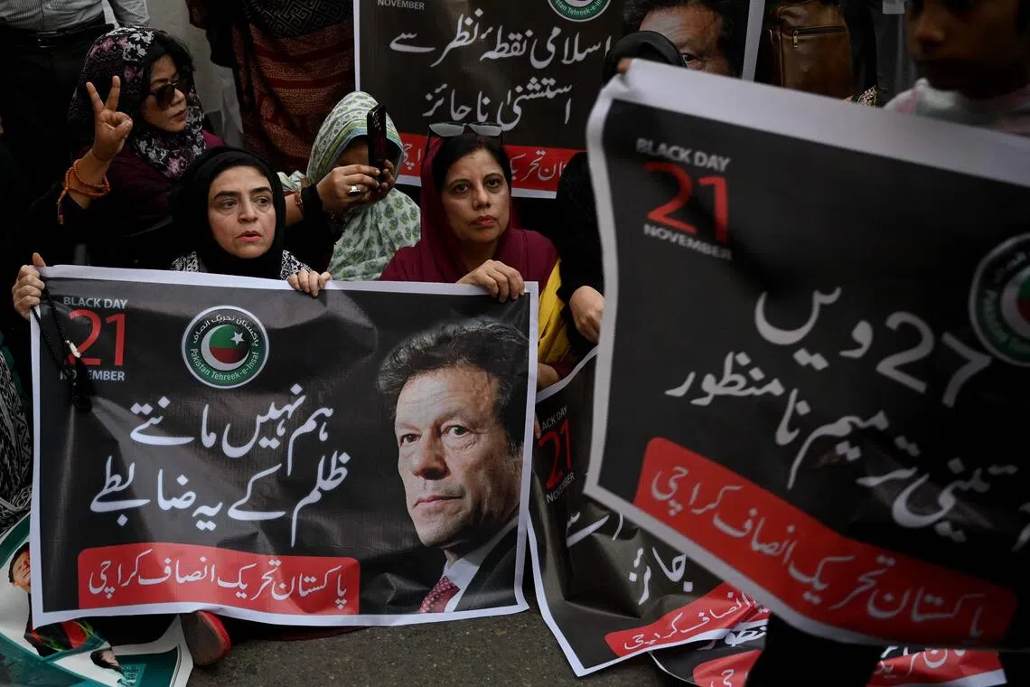 Pakistan Tehreek-e-Insaf party supporters carry a poster of their leader and former prime minister Imran Khan, during a protest against the 27th constitutional amendment, in Karachi on Nov 21. 