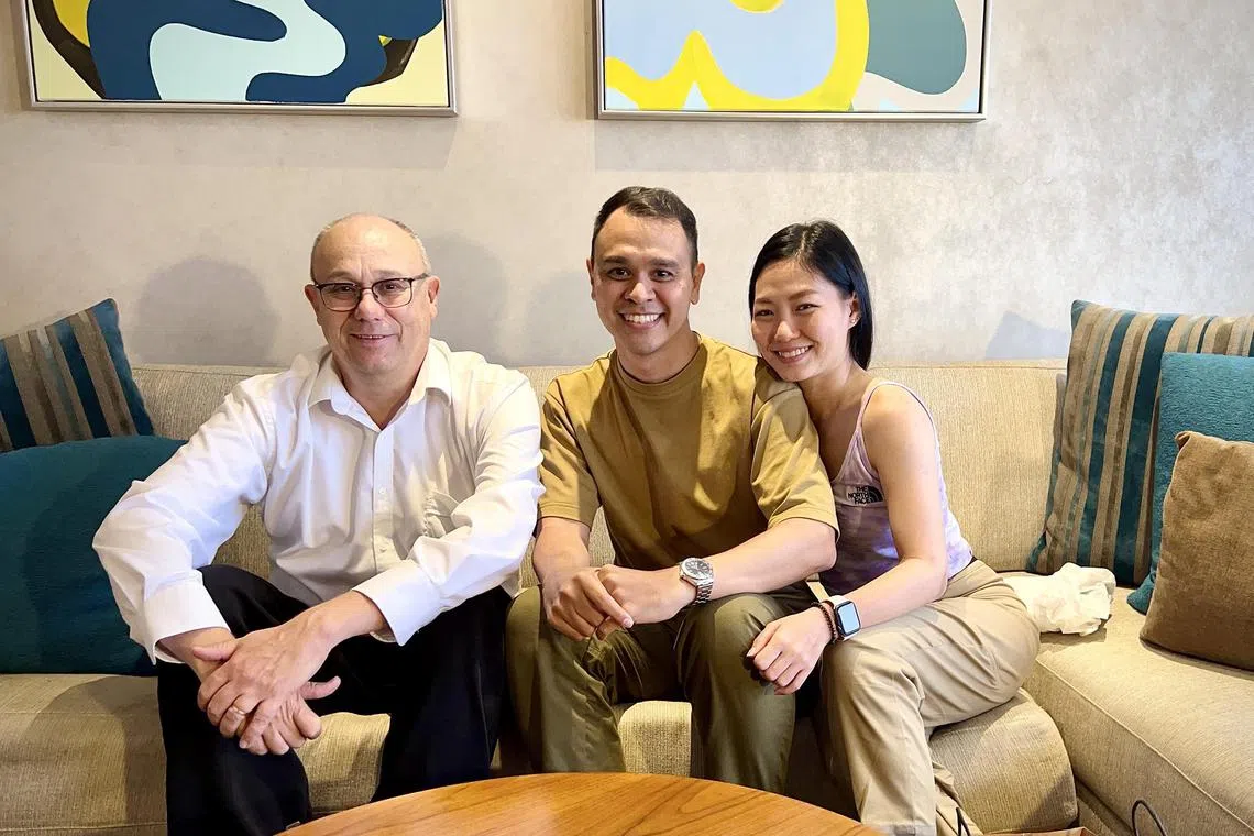 Mr Michael Scheck, Mr Wesley Aroozoo and his wife Ms Ho Shengjuan pose for a photograph at a hotel room in Brisbane., Australia.