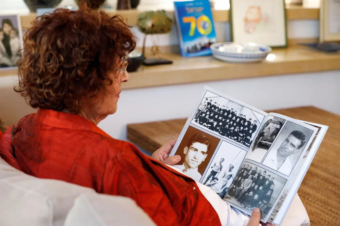 FILE PHOTO: Nadia, widow of Israeli spy Eli Cohen, looks at photographs depicting her late husband during an interview with Reuters in Herzliya, Israel October 6, 2019. Picture taken October 6, 2019. REUTERS/Amir Cohen/File Photo