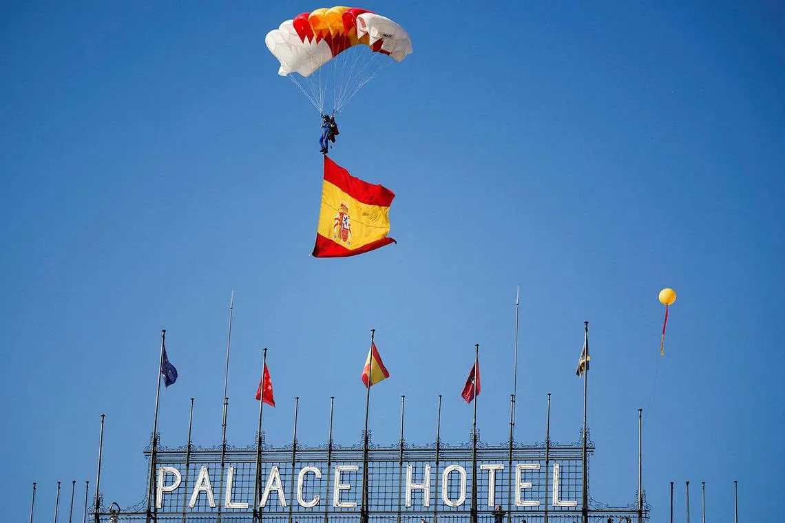A skydiver waving Spain's flag attends a military parade to mark Spain's National Day, in Madrid, Spain, Oct 12.