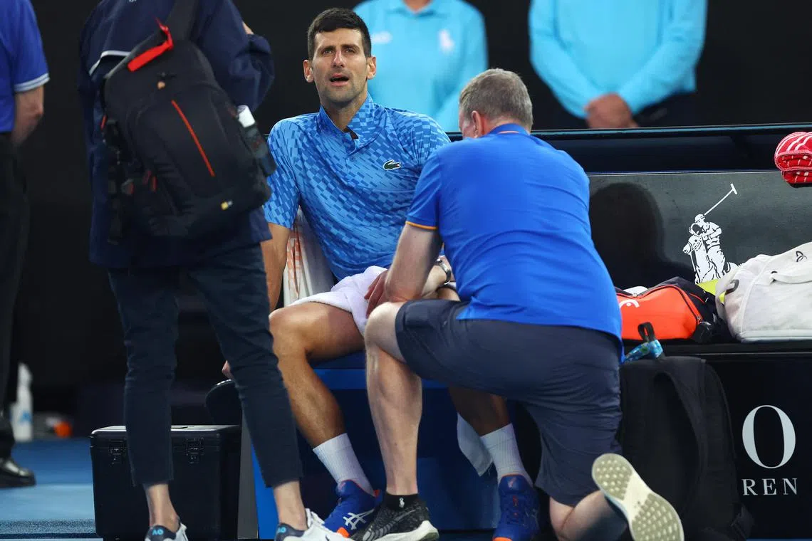 Serbia's Novak Djokovic receives medical attention after sustaining an injury during his third round match against Bulgaria's Grigor Dimitrov.