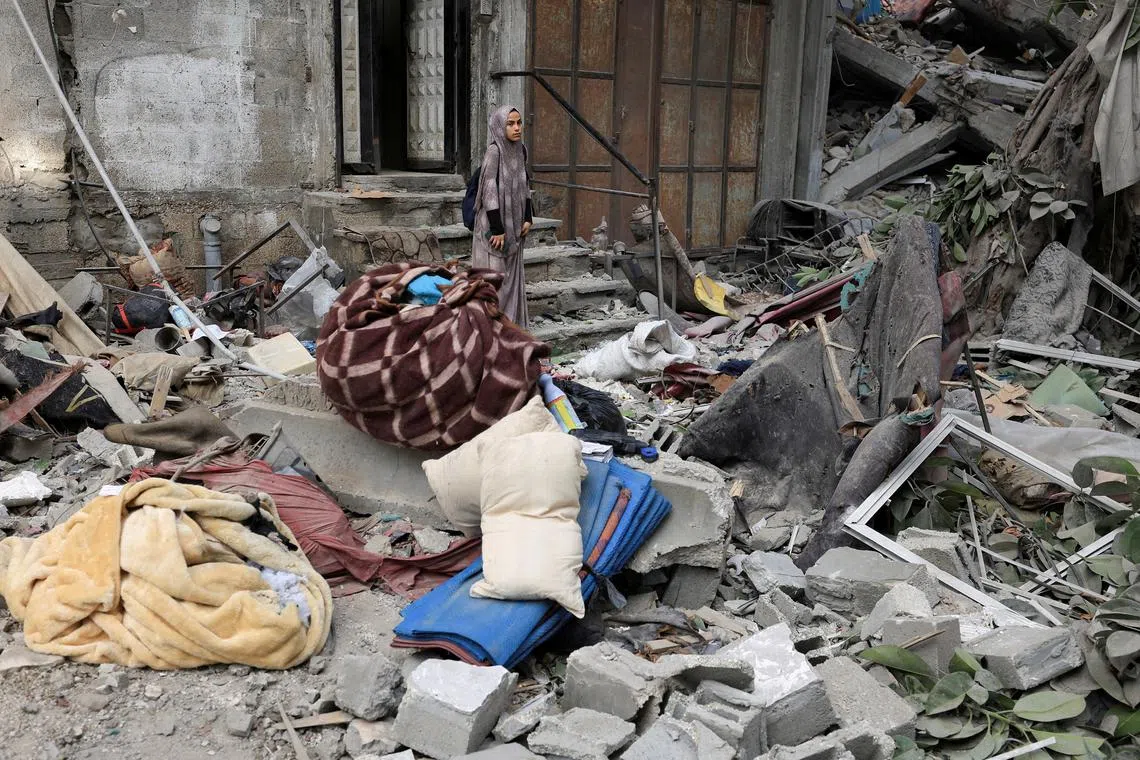 FILE PHOTO: A Palestinian woman inspects the site of an overnight Israeli strike on a house, in Gaza City August 7, 2025. REUTERS/Dawoud Abu Alkas/File Photo