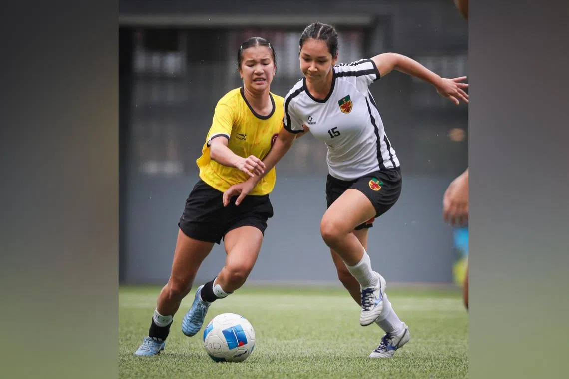 Victoria Junior College's two-goal heroine Tyan Foong (left) challenging Raffles Institution's Calista Dodson in the girls' A division football final.