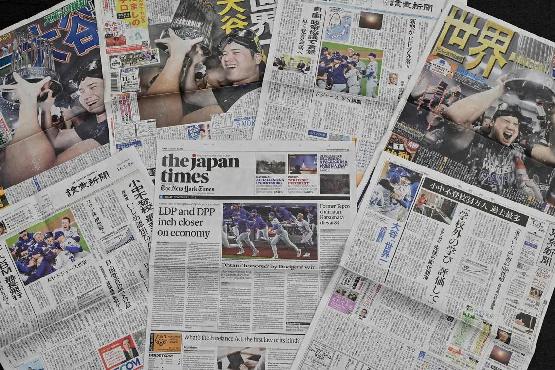 This photo illustration shows a selection of newpapers' front pages in Tokyo on Nov 1, 2024, with images of Shohei Ohtani and the Los Angeles Dodgers celebrating their victory over the New York Yankees in the Major League Baseball (MLB) World Series.