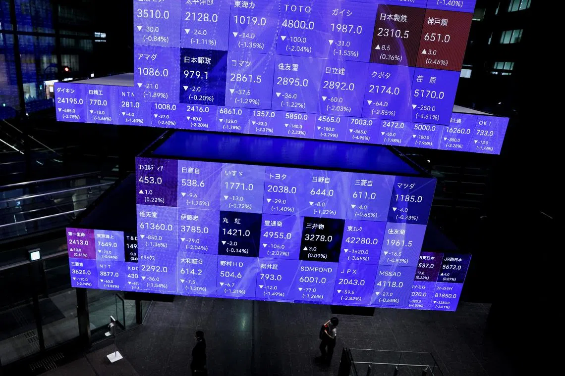 Visitors walk past Japan's Nikkei stock prices quotation board inside a conference hall in Tokyo, Japan September 14, 2022. REUTERS/Issei Kato