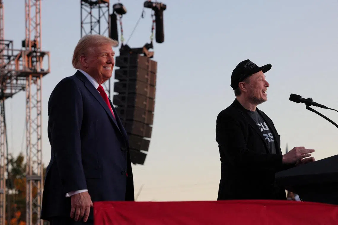 Elon Musk (right) speaks as Republican presidential nominee Donald Trump looks on during a rally at the site of the July assassination attempt against Trump, in Butler, Pennsylvania, on Oct 5.