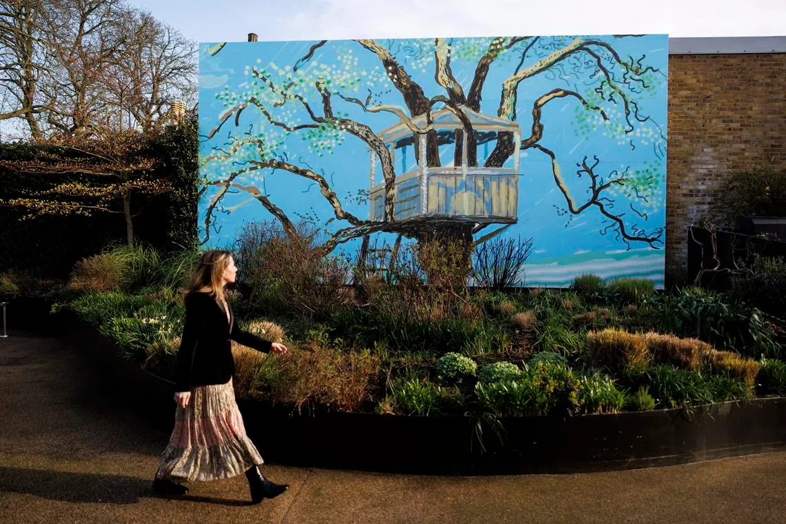 A staff member of the gallery posing with a large-scale printed mural by British artist David Hockney during the press preview for the A Year In Normandie And Some Other Thoughts About Painting exhibition at Serpentine North Gallery in London, Britain, March 11. 