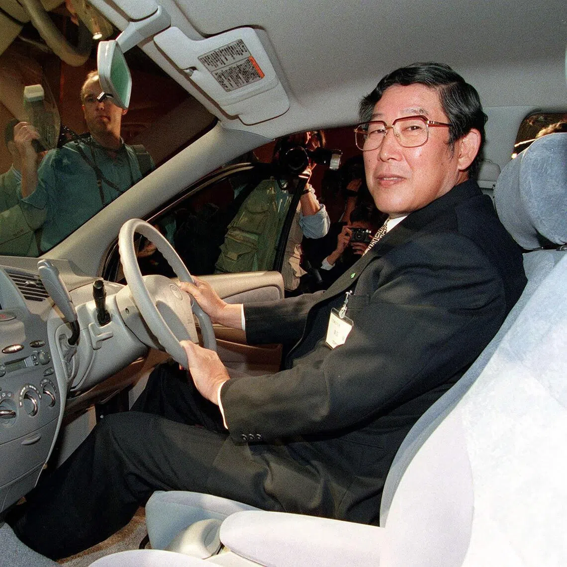 Japan’s former Toyota Motor Corp President Hiroshi Okuda sitting in the driver’s seat of the newly developed Prius on Oct 14, 1997.