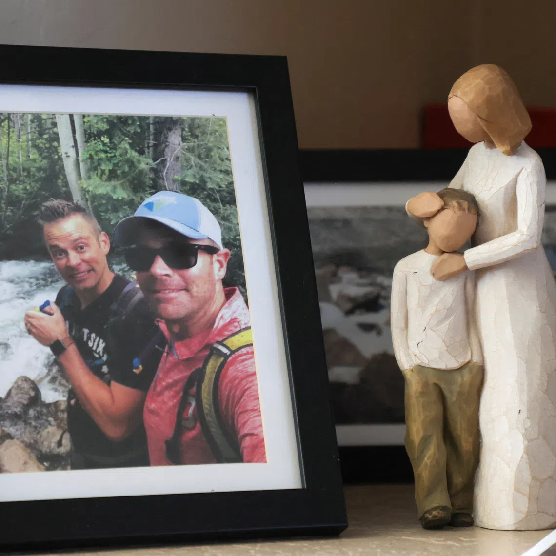 A framed photo of pilot Brian Wittke and his brother stands next to a mother and son figurine on a memorial shelf at his mother's home in Glendale, Arizona, U.S., October 6, 2025. REUTERS/Erica Stapleton