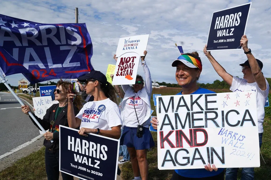 CUMMING, GEORGIA - OCTOBER 15: People hold signs in support of Democratic presidential nominee, Vice President Kamala Harris ahead of Republican presidential nominee, former President Donald Trump visiting for a townhall event on October 15, 2024 in Cumming, Georgia. The two candidates have scheduled multiple events in battleground states ahead of the November 5 election.   Megan Varner/Getty Images/AFP (Photo by Megan Varner / GETTY IMAGES NORTH AMERICA / Getty Images via AFP)