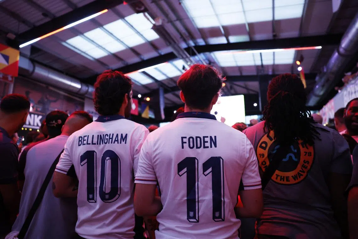 FILE PHOTO: Soccer Football - Euro 2024 - Fans gather for England v Slovenia - London, Britain - June 25, 2024 England fans wearing Jude Bellingham and Phil Foden shirts watch the match at BoxPark Wembley Action Images via Reuters/Andrew Couldridge/File Photo