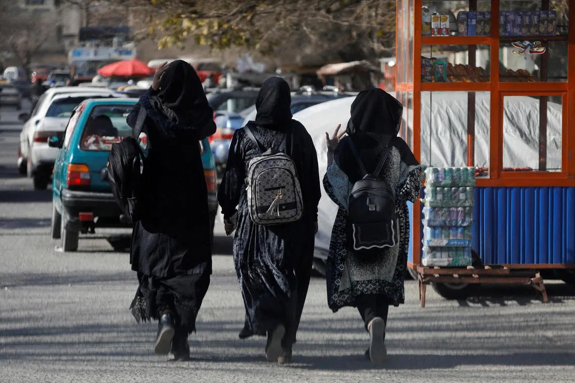 Afghan female students walk near Kabul University in Kabul, Afghanistan.