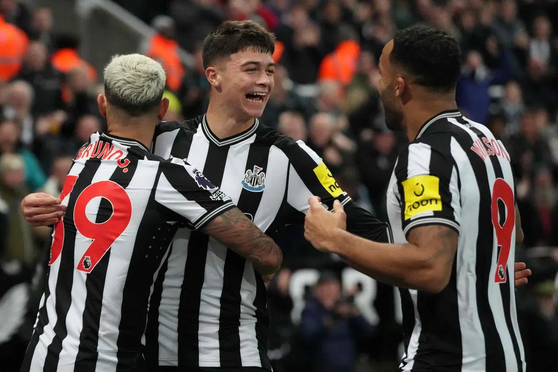 Newcastle United's 17-year-old midfielder Lewis Miley (centre) celebrates with teammates Bruno Guimaraes (left) and Callum Wilson after scoring the opening goal.
